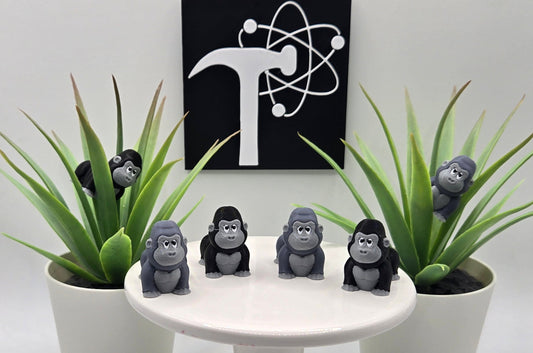 mini articulated gorillas on a white pedestal with plants and the Crafticist logo in the background
