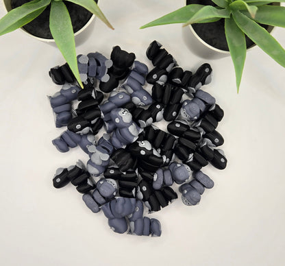 a pile of articulated gorilla toys on a white surface with plants