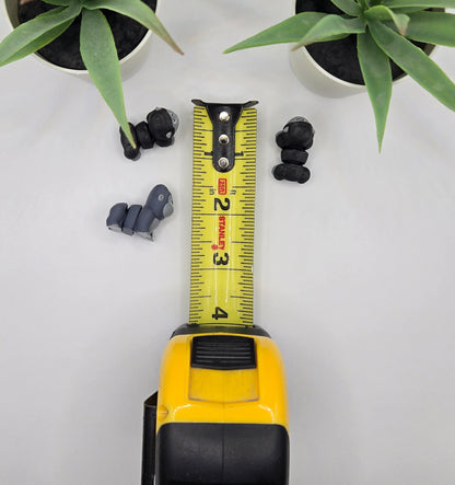 mini articulated gorillas with a tape measure on a white background with plants