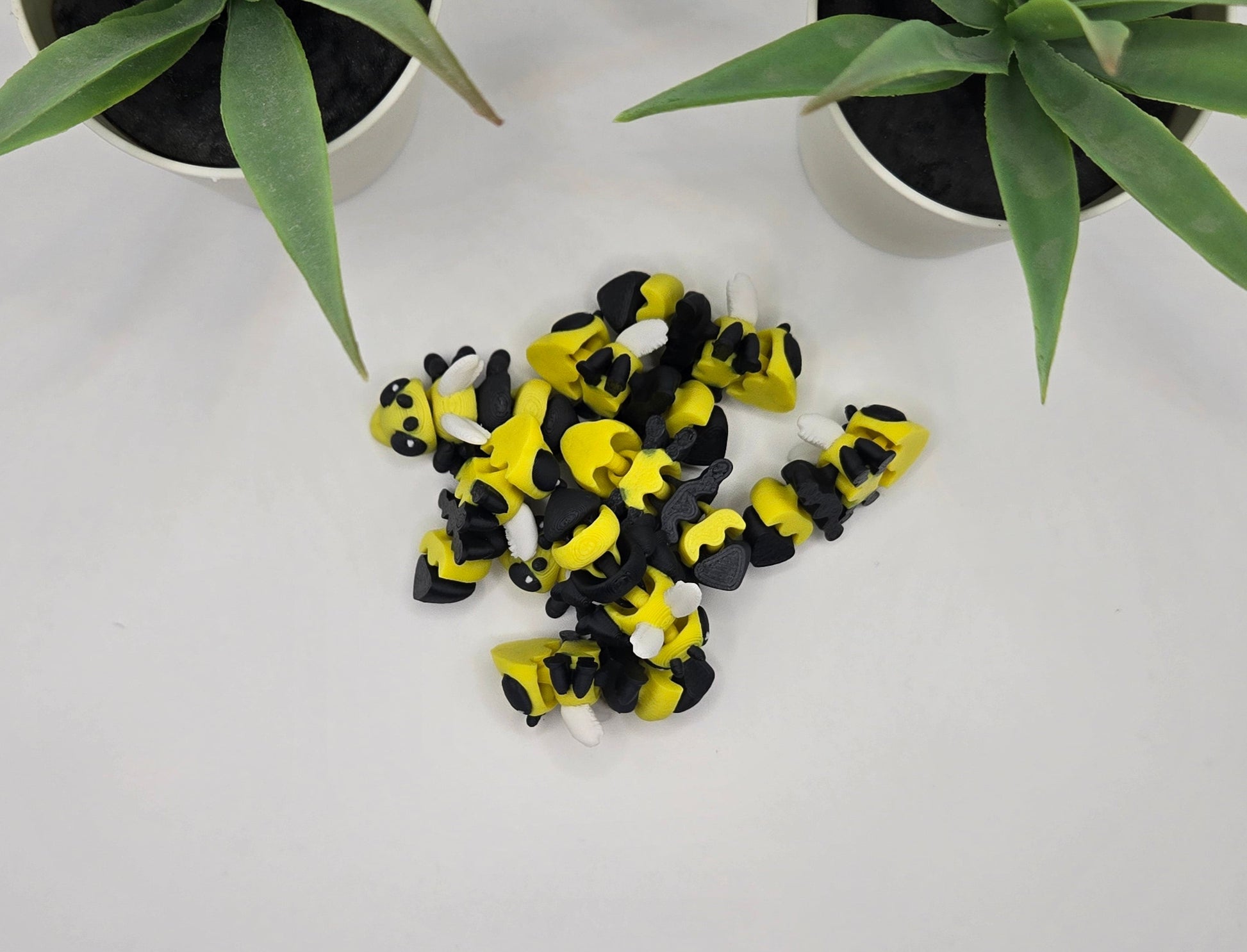 a pile of mini articulated hornet toys on a white background with plants in the background