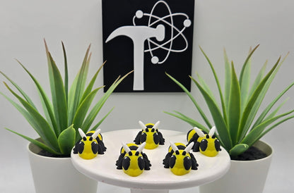mini articulated hornet toys on a white pedestal with plants and the crafticist logo in the background