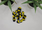 a pile of mini articulated bee toys on a white surface with plants in the background