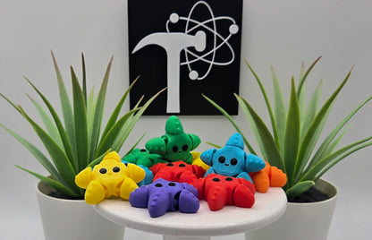 colorful articulated starfish on a white pedestal with two plants and the Crafticist logo in the background.