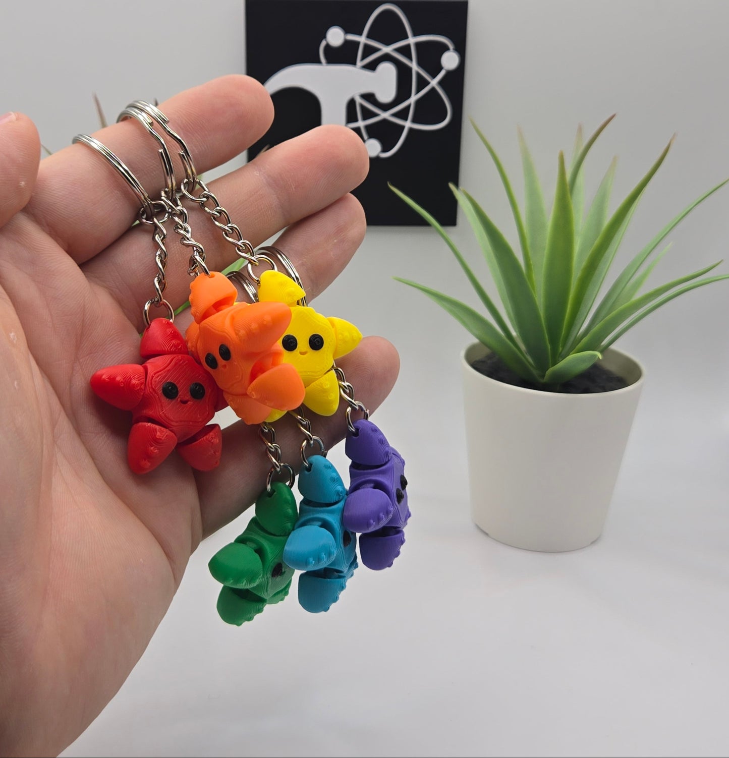 mini articulated starfish on keychains with plants and the crafticist logo in the background