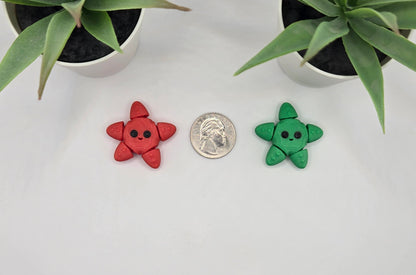 two small articulated starfish with a quarter on a white surface with plants in the background